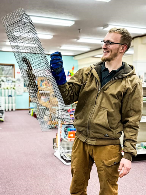 A man holding a trapped squirrel inside an MCC Thrift shop.