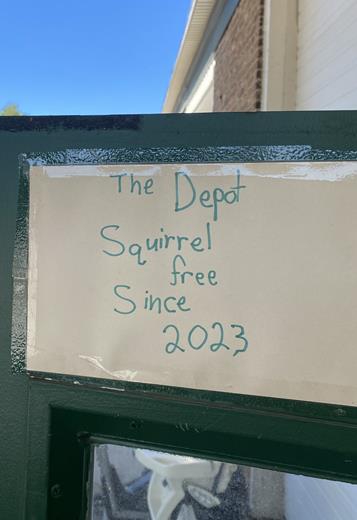 A sign that says, "The Depot: Squirrel free since 2023."