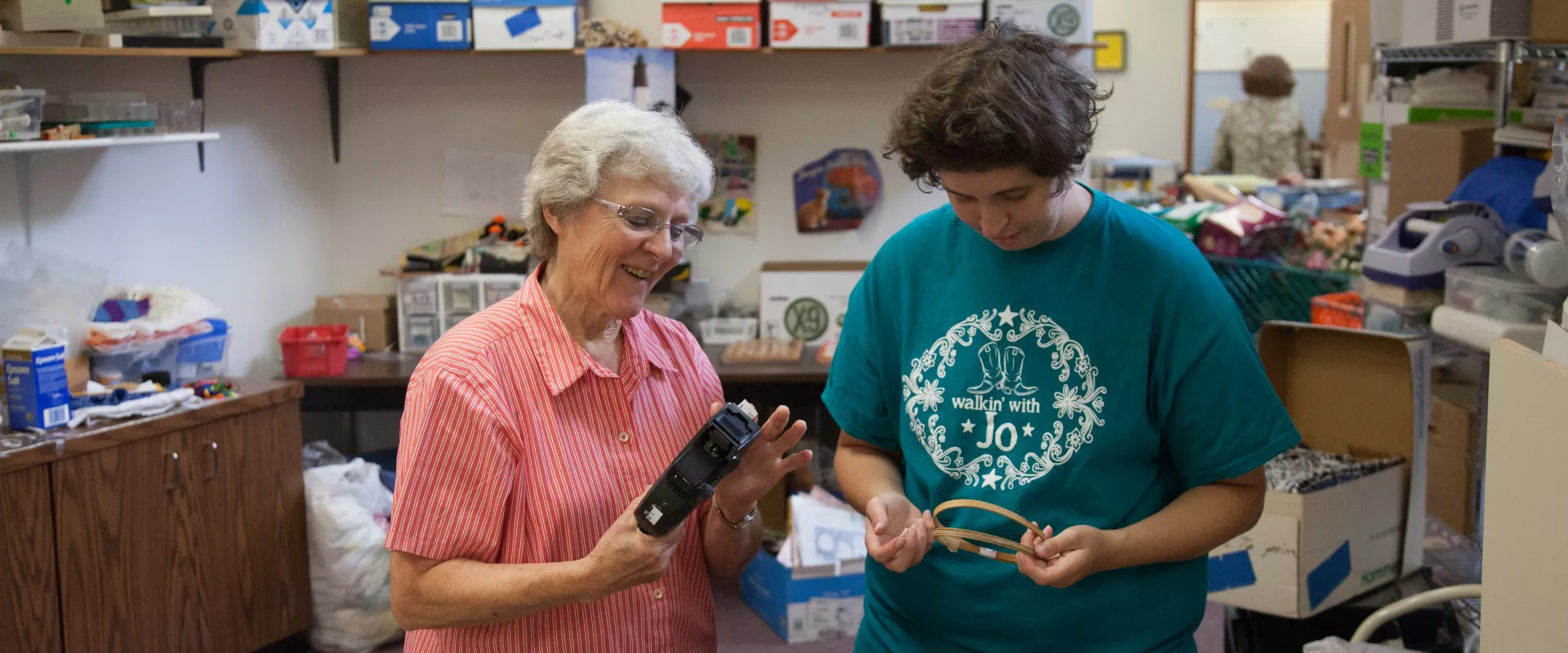 Two women volunteering with MCC Thrift, working with embroidery hoops.